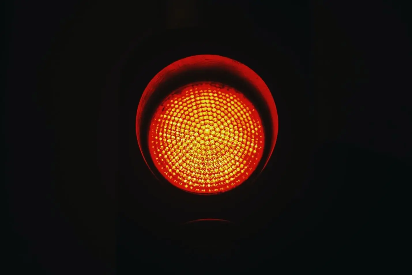A red traffic light glows, symbolizing caution and signaling drivers to stop.